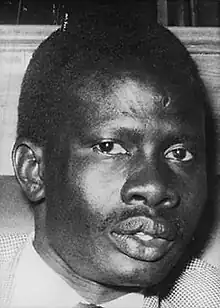 Abel Alier. Schwarz-Weiß-Porträt eines Afrikaners mit kahlem Kopf.