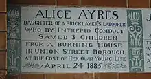 A tablet formed of six standard sized tiles, bordered by green flowers in the style of the Arts and Crafts movement