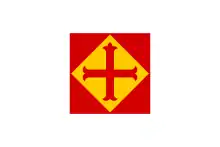 Rotes Quadrat, indem sich eine gelbe Rombe mit rotem Kreuz befindet; die rechteckige Grundfläche ist weiß