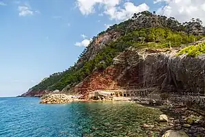 Blick auf den steinigen Strand, die Bootshäuser und den Bootsanleger