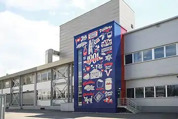 12 m hohes Graffiti von Serge Nidegger zum 120-Jahr-Jubiläum der Firma im Jahr 2021 am Bürogebäude in Freiburg i. Üe.