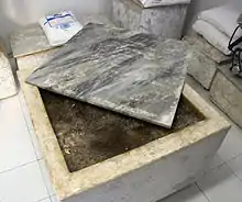 Marmortrog mit zur Reifung eingelegtem Lardo, oben ist die Marmorplatte zum Abdecken zu sehen