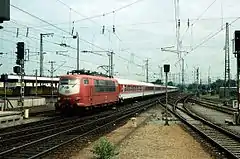 InterCity-Wagengarnitur im orientroten / pastellvioletten Farbschema mit Lok 103&nbsp;197 bei der Einfahrt in den Karlsruher Hauptbahnhof