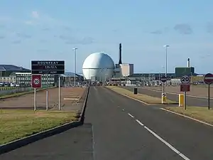 Zufahrt zur Anlage mit dem DFR-Reaktor im Vordergrund und dem PFR-Gebäude rechts im Hintergrund. Nicht im Bild: Der MTR befindet sich am nördlichen Teil der Anlage. Vulcan/Naval Reactor befindet sich am westlichen Ende.