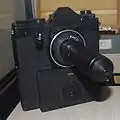 Kamera mit Sonderobjektiv SO-3.5.1 zum konspirativen Fotografieren. Das Objektiv konnte auf eine geräuscharme Spiegelreflexkamera geschraubt werden. Damit war es möglich, durch ein Loch von 1&nbsp;mm Durchmesser zu fotografieren.