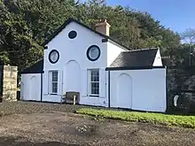 Fotografie der Garron Lodge mit Ochsenaugen und Ziermauer