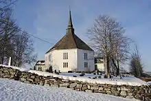 Foto einer weißen Holzkirche in verschneiter Umgebung