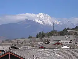 Blick über die Dächer von Lijiang auf den Yulong Xueshan (玉龙雪山 – „Jadedrachen-Schneeberg“, 5596 Meter)
