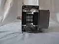 Magnetron eines Mikrowellenherdes von der Seite: schwarz seitlich der Kühlrippen: die Magnete.