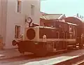 Kleinlok der Baureihe 333 mit einem Übergabe-Güterzug vor dem Bahnhofsgebäude Marquartstein im August 1975