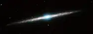 Infrarotaufnahme, Spitzer-­Welt­raum­tele­skop. Ein Ring aus Gas und Staub tritt bei 8&nbsp;µm Wellen­länge (rot) hervor, das Sternen­licht des Bulges bei 3,6&nbsp;µm (blau).