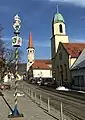 Ortsmitte mit Narren­baum der Oberkochener Narrenzunft „Schlagga-Wäscher“, Stadtbi­blio­thek und St. Peter und Paul