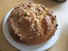Ein Osterfladen mit Mandelblatt- und Hagelzuckerverierung auf einem weißen Teller