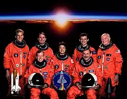 v.&nbsp;l.&nbsp;n.&nbsp;r. vorne: Steven Lindsey, Curtis Brown; hinten: Scott Parazynski, Stephen Robinson, Chiaki Mukai, Pedro Duque und John Glenn