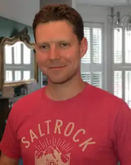 Profilfoto eines Mannes mit kurzen braunen Haaren, der in die Kamera lächelt