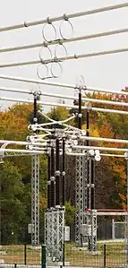 Eine Gruppe von drei Trennern (Bauart Pantograf- oder Scherentrenner, geöffnet) in einer Freiluftschaltanlage für 380&nbsp;kV