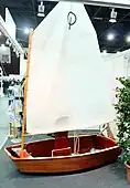 Optimist mit traditionellem Sperrholzrumpf ausgestellt auf einer Messe