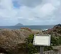 Schild. Am Horizont die 10&nbsp;km entfernte, bereits zum Bundesstaat Tasmanien gehörige Rodondo Island