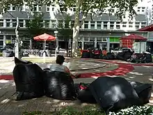 Bild von Menschen die auf einem Platz sitzen und Lesen