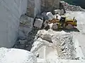Steintransport mit Radlader, der tonnenschwere Rohblöcke hebt
