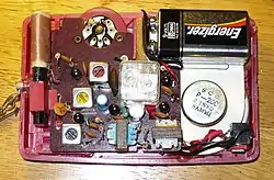Geöffnetes AM-Mittelwellen-Transistorradio aus dem Jahre 1960 mit zwei Kreisen, erkenntlich an dem mittig montierten doppelten Drehkondensator, der mittels einer Drehscheibe auf der Frontseite des Radios zur Sendereinstellung bedienbar war.