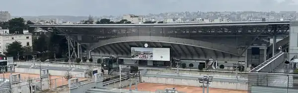 Außenansicht des Court Suzanne Lenglen nach Erweiterungsbau 2024 mit 15.000 Plätzen und ausfahrbarem Dach. Im Vordergrund eine neue Leinwand für ein Public Viewing.