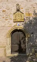 Seiteneingang der Kirche mit Wappen