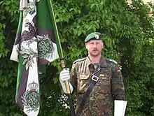 Hauptfeldwebel mit Nach­bildung der Truppen­fahne der Rhein­ischen Jäger (Rhein­isches Jäger-Bataillon Nr.&nbsp;8) HSchBtl 56