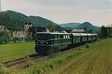 Der erste Triestingtalexpress gezogen von der 2050.02 am 1.&nbsp;Mai 2005 in Thenneberg. Im Hintergrund ist die Kirche zu sehen.
