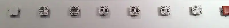 Steps in manufacturing Solid Logic Technology hybrid modules. The process starts with a blank ceramic wafer, 1⁄2 inch (13 mm) square. Circuits are laid down first, followed by resistive material. Pins are added, the circuits are soldered and the resistors trimmed to the desired value. Then individual transistors and diodes are added and the package is encapsulated.